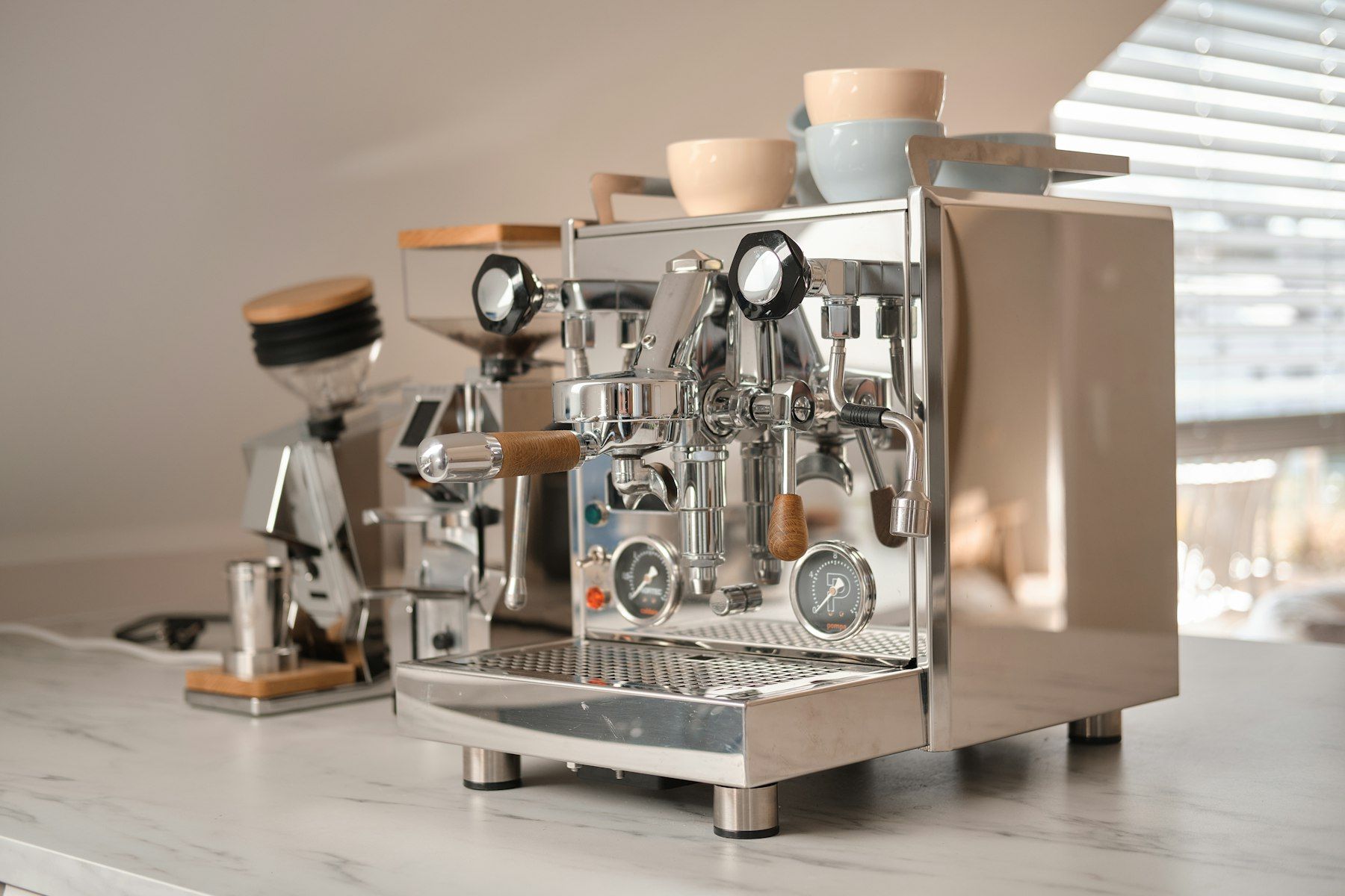 Chromen espressomachine en molen op een marmeren aanrecht