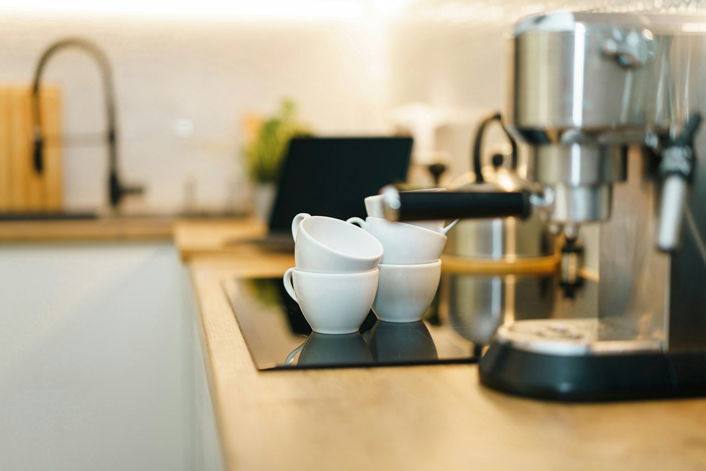 Koffiemachine met kopjes in een lichte keuken